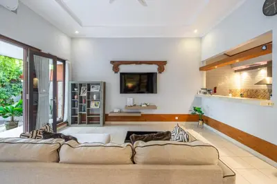 a living room with a couch and a tv at Nameera Villa in Seminyak