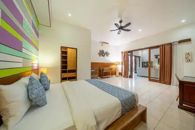 a bedroom with a bed and a ceiling fan at Nameera Villa in Seminyak