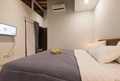a stuffed animal laying on a bed in a bedroom at Vpas Villa in Seminyak