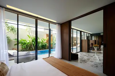 a bedroom with a bed and large glass windows at New Luxury Villa Adamare 1 in Kerobokan