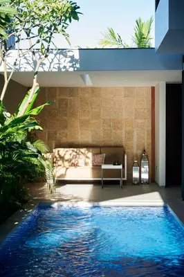a living room with a couch and a swimming pool at New Luxury Villa Adamare 1 in Kerobokan