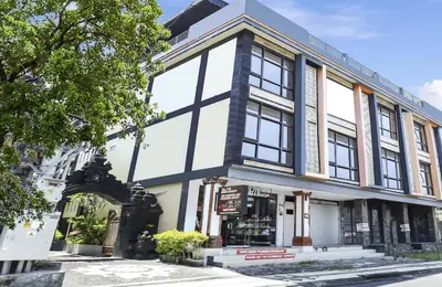 a building with a lot of windows on a street at Moreno Homestay in Legian