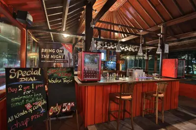 a bar in a restaurant with two stools at Club Bali Suite Legian in Legian