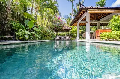 a swimming pool in a resort with a gazebo at Baliani Beauty in Seminyak
