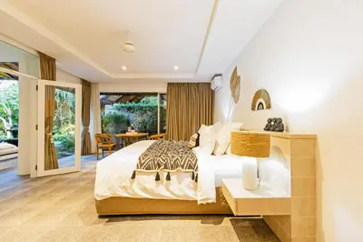 a bedroom with a king sized bed and a patio at Baliani Beauty in Seminyak