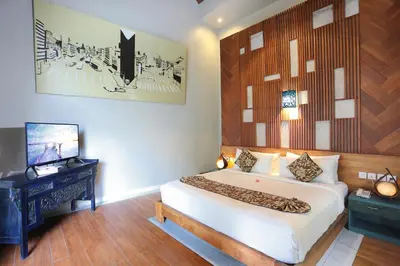 a bedroom with a large bed and a television at The Reward Villas in Seminyak