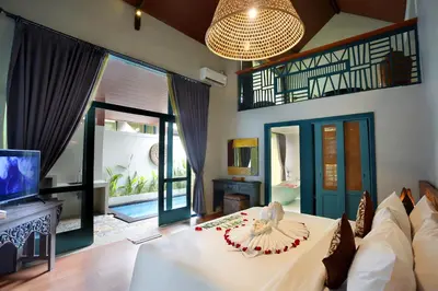 a bedroom with a bed and a tv in a room at The Reward Villas in Seminyak