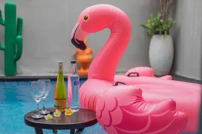 a pink flamingo toy next to a table with drinks at The Reward Villas in Seminyak