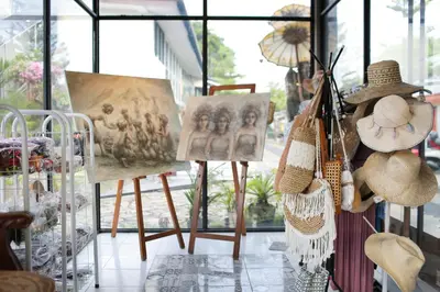 a room with paintings and hats on display in a store at The Reward Villas in Seminyak