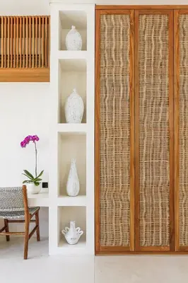a sliding glass door with vases on shelves at Casa Umalas Villa by Betterplace in Canggu