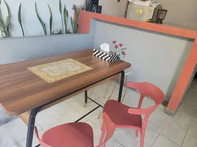 a table and two red chairs in a room at 9 Residence's Seminyak in Seminyak