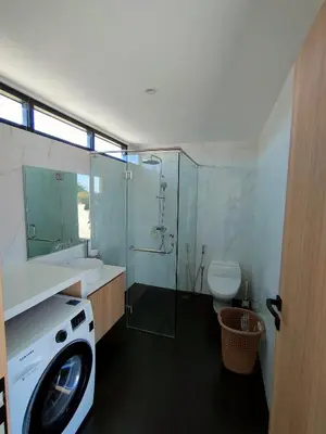 a bathroom with a sink and a washing machine at Milo Modern Five-Bedrooms Villa in Jimbaran