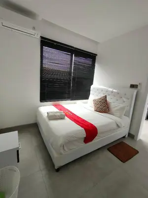 a bedroom with a white bed with a red blanket on it at Milo Modern Five-Bedrooms Villa in Jimbaran