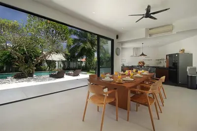 a dining room and kitchen with a table and chairs at Villa Papaya by Optimum Bali Villas in Canggu